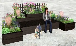 En kvinna och en hund njuter av en vacker rabatt med perenner.